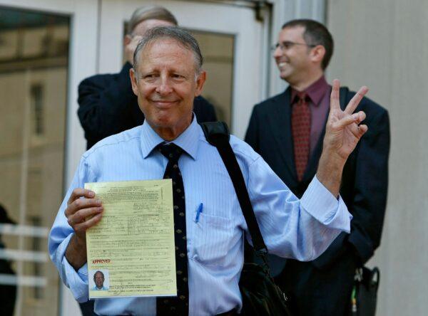 Dick Heller, the plaintiff in the Supreme Court case Heller v. District of Columbia, gestures while holding his newly approved gun permit at the District of Columbia Police Department on Aug. 18, 2008. (Mark Wilson/Getty Images)