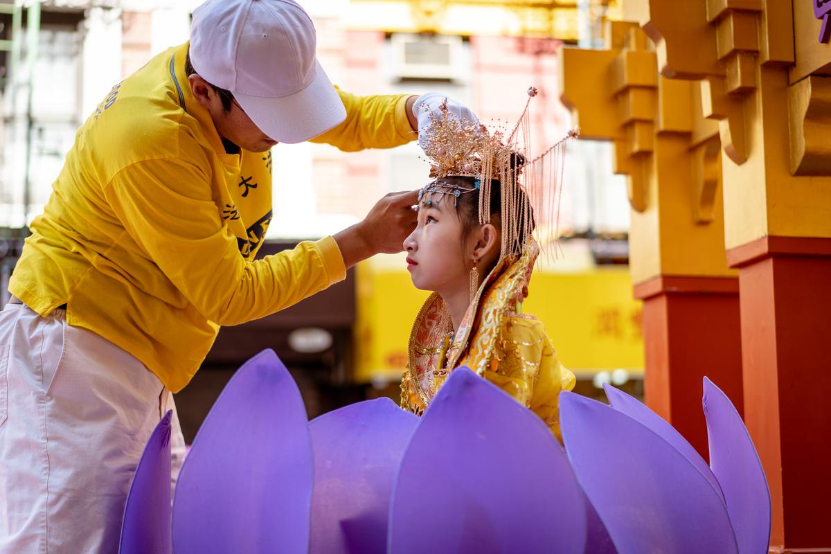A young Falun Gong practitioner gets ready to take part in a parade to commemorate the 23rd anniversary of the persecution of the spiritual discipline in China, in New York's Chinatown on July 10, 2022. (Samira Bouaou/The Epoch Times)