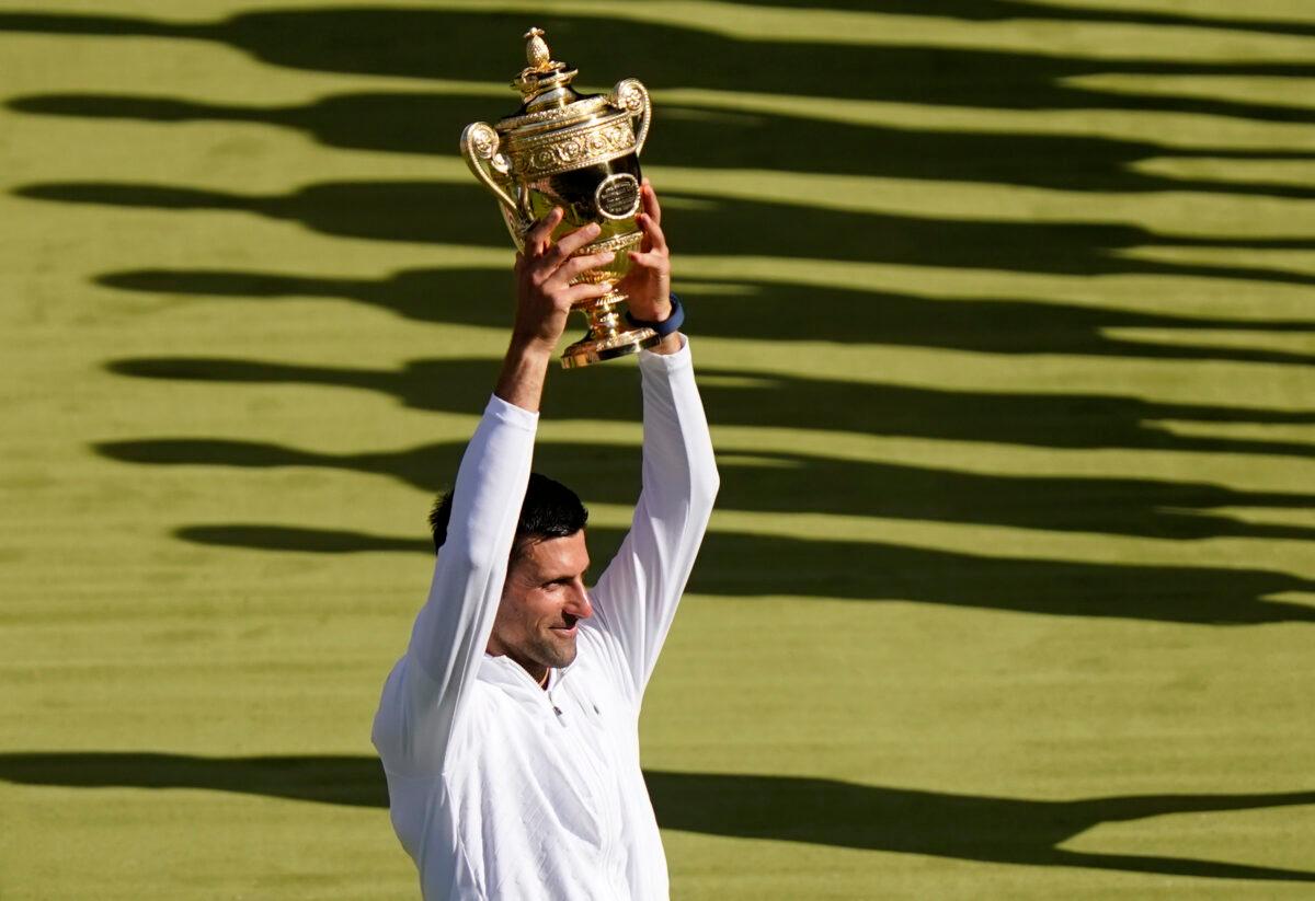 Serbia's Novak Djokovic celebrates with the trophy after beating Australia's Nick Kyrgios in the final of the men's singles on day fourteen of the Wimbledon tennis championships in London on July 10, 2022. (Gerald Herbert/AP Photo)