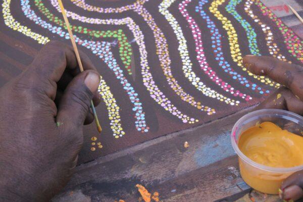 Indigenous artist dot painting in Derby, Western Australia.(Rafael Ben-Ari/Adobe Stock)