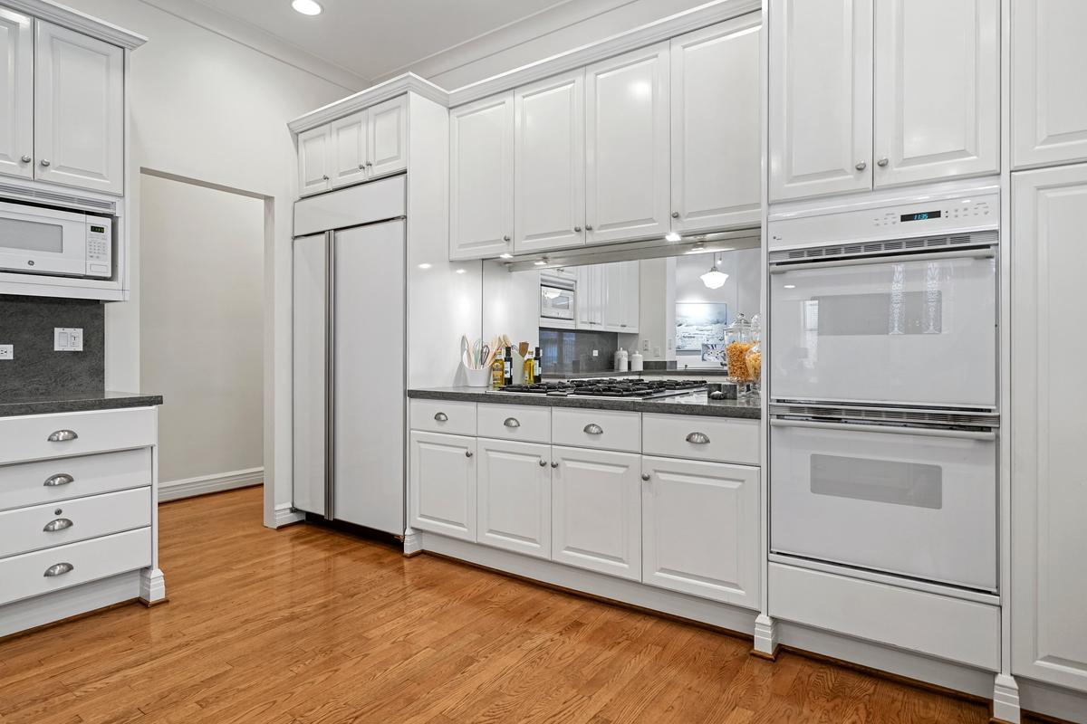 The large kitchen has been upgraded to include a double oven, a gas range, and other state-of-the-art appliances. There’s also an eat-in bar that connects with the living space. (Courtesy of Americorp Ltd-Laricy)