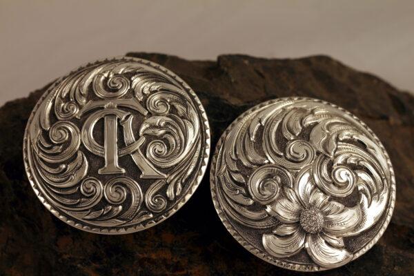 Pair of bridle conchos (round silver ornaments), 2019, by Scott Hardy. Sterling silver engraved and sculpted, with sterling silver scroll and monogram overlays. (Leslie Hardy)
