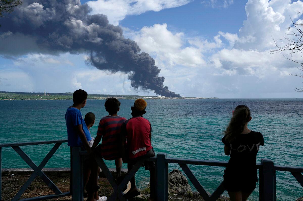 People watch a huge rising plume of smoke caused by a blaze at the Matanzas Supertanker Base, in Matazanas, Cuba, on Aug. 6, 2022. (Ramon Espinosa/AP Photo)