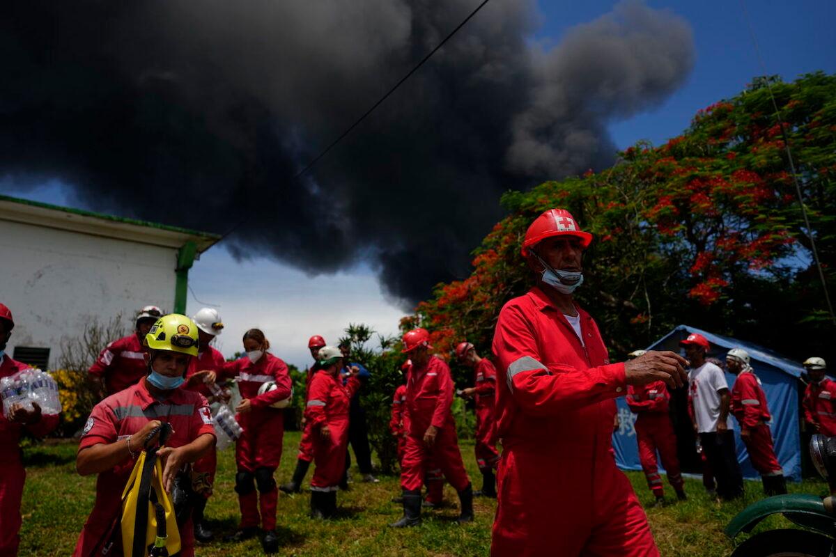 Members of the Cuban Red Cross prepare to be transported to the Matanzas Supertanker Base, where firefighters work to quell a blaze which began during a thunderstorm the night before, in Matazanas, Cuba, on Aug. 6, 2022. (Ramon Espinosa/AP Photo)