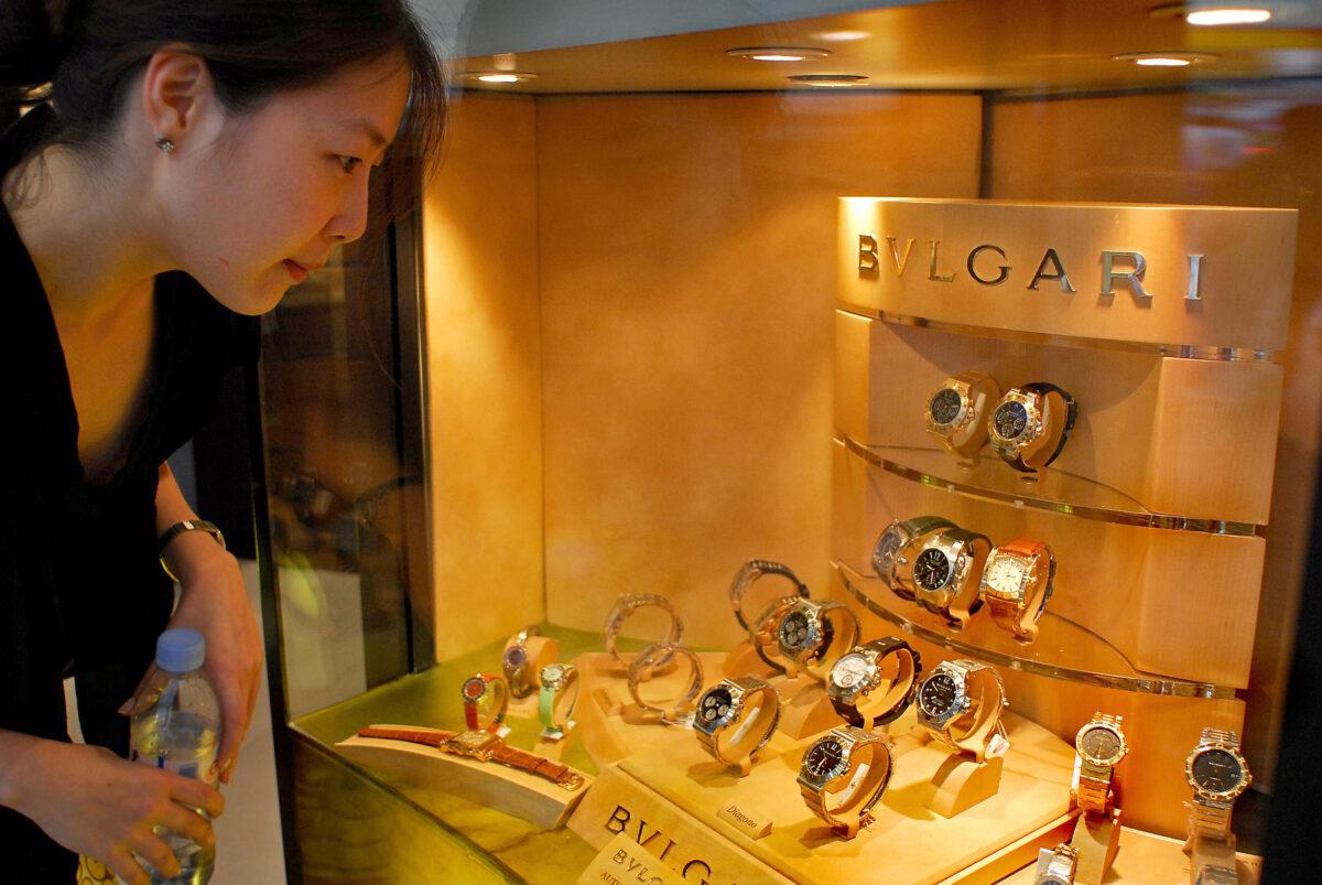 A woman looks at luxury watches displayed in a shop in Hong Kong on April 14, 2006. (PHILIPPE LOPEZ/AFP via Getty Images)