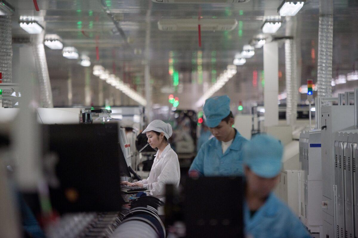 Workers build smartphone chip component circuits at the Oppo factory in Dongguan, Guangdong Province, on May 8, 2017. (NICOLAS ASFOURI/AFP via Getty Images)
