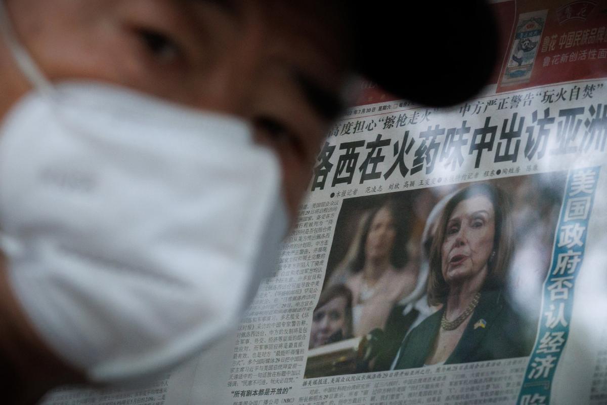 A man stands in front of a glass cabinet displaying the Global Times newspaper that features a front page article about U.S. House Speaker Nancy Pelosi's Asia tour in Beijing on Aug. 1, 2022. The front page headline reads: "Pelosi visits Asia in the smell of gunpowder." REUTERS/Thomas Peter
