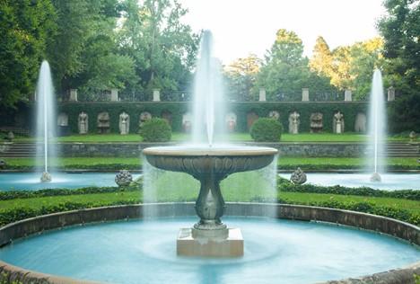In the Italian Water Garden, the calm, horizontal lines of the lawn are lightly punctuated with shrubs and urns of fruit. Niches frame the wall fountains and sculpted trophies (made from limestone), establishing a rhythm below the raised viewing platform seen in the background. The light blue Italian tiles and delicately flowing fountains create an allure of pristine waters. (Courtesy of J.H.Smith/Cartiophotos)