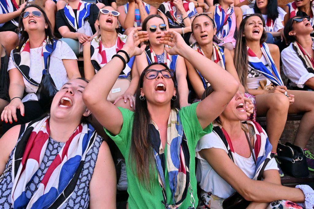 Supporters of the "Istrice" (Crested Porcupine) contrada, or city ward, cheer as they gather at Piazza del Campo for a rehearsal on the eve of the Palio di Siena horse race on July 1, 2022, in Siena, Tuscany. (ALBERTO PIZZOLI/AFP via Getty Images)