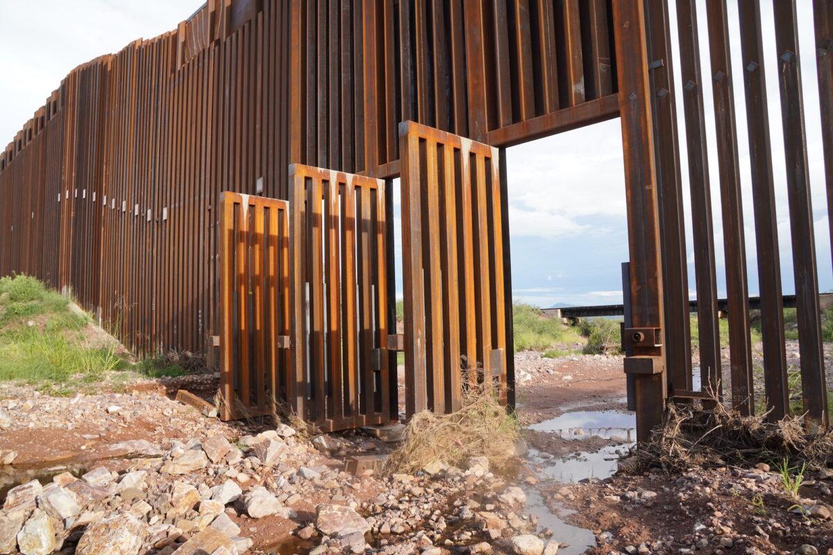 Open floodgates provide easy access for illegal aliens crossing into the United States from Mexico along the southern border wall fence in Douglas, Ariz., on Aug. 24. (Allan Stein/The Epoch Times)