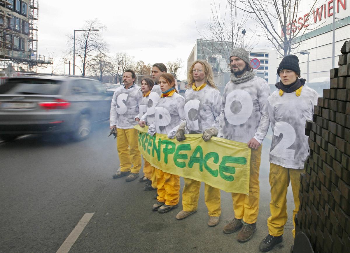 Representatives of car companies arrive at the Vienna Autoshow as Greenpeace activists protest against carbon dioxide (CO2) emissions from sports utility vehicle cars (SUV) on Jan. 16, 2008. (Dieter Nagl/AFP via Getty Images)