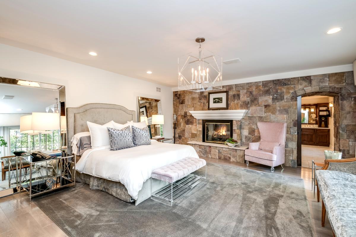 The master bedroom features its own fireplace, an exquisite bath, spacious closets, and large picture window views. The adjacent room is well-suited for use as a home gym or office. (Jade Mills)