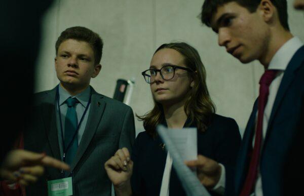 Candidates (L–R) Tate Olens, Alex Goldbeck, and Aidan Blain confer on their next steps in the race for Youth Governor at the California Youth and Government Conference in a scene from the documentary "The Youth Governor" by Matthew Halmy and Jaron Halmy. (Greenwich Entertainment)