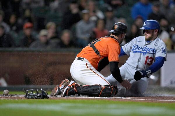Los Angeles Dodgers' Max Muncy (13) slides into home plate to score past San Francisco Giants catcher Joey Bart, left, who drops the ball during the second inning of a baseball game in San Francisco, on Sept. 16, 2022. (Tony Avelar/AP Photo)