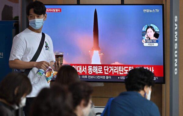 People watch a television screen showing a news broadcast with file footage of a North Korean missile test, at a railway station in Seoul, South Korea, on Sept. 25, 2022.(Jung Yeon-je/AFP via Getty Images)