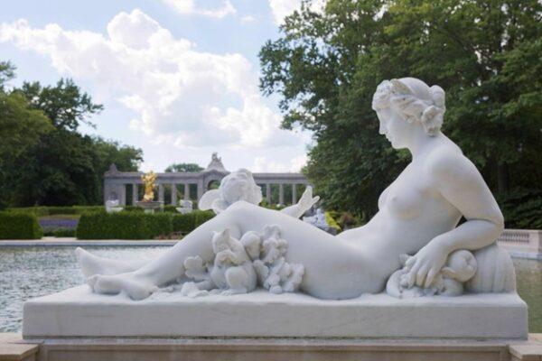 Surrounding the Reflection Pond are sculptures by French-born American artist Henri Crenier representing the four seasons. Summer appears here with fruit under an arm, a squirrel nearby, and a cherub gesturing toward her. (Courtesy of Grace Khmelev)