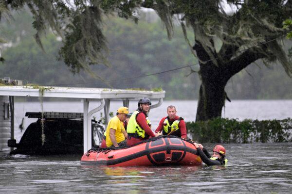 First responders with Orange County Fire Rescue use an inflatable boat to rescue a resident from a home in the aftermath of Hurricane Ian, in Orlando, Fla., on Sept. 29, 2022. (Phelan M. Ebenhack/AP Photo)