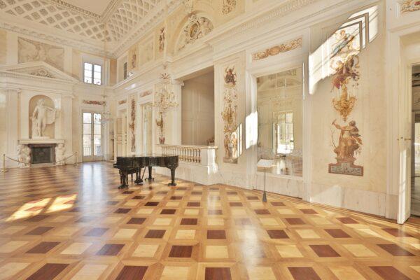 The Ballroom, a light and airy neoclassical-style ceremonial space, was designed for the king to receive his public and important guests. Soft frescoes on the wall feature the four seasons; a sculptural relief features the white eagle, a symbol of Poland and a motif seen in ancient Rome. The room never fulfilled its full ceremonial purpose due to the partitioning of Poland and the king’s abdication. (Royal Lazienki Museum)
