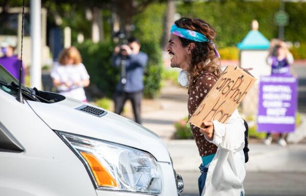 A transgender activist blocks a vehicle in Anaheim, Calif., on Oct. 8, 2022. (John Fredricks/The Epoch Times)