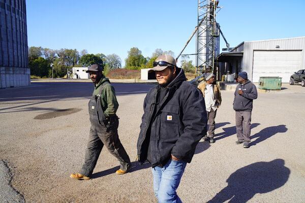 Barge loader Raul Rivas (R), deckhand Clifton Brown (L), and other workers at Poinsett Rice and Grain in Osceola, Ark., walk to the loading docks on Oct. 20, 2022. (Allan Stein/The Epoch Times)