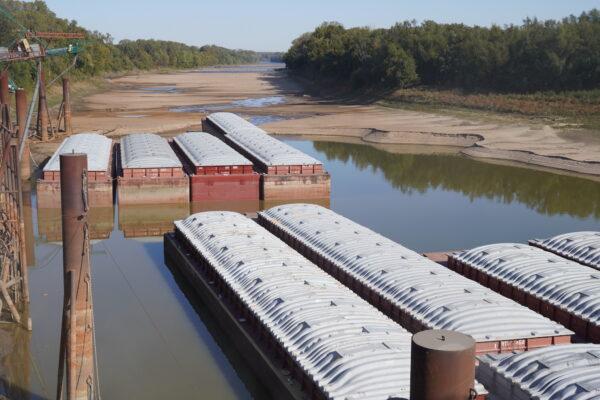 Barges sit in the port facility at Poinsett Rice and Grain in Osceola, Ark., on Oct. 20, 2022. Behind the barges, the river tributary's water line has been receding for months in the continuing drought. (Allan Stein/The Epoch Times)
