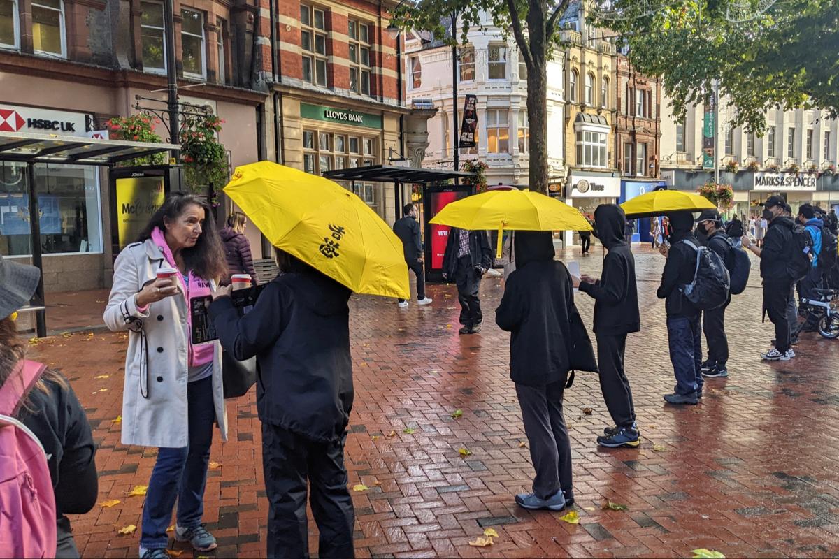 Reading Human Chain participants briefed passers-by about the beating incident at the Chinese consulate in Manchester (Shan Lam/The Epoch Times)
