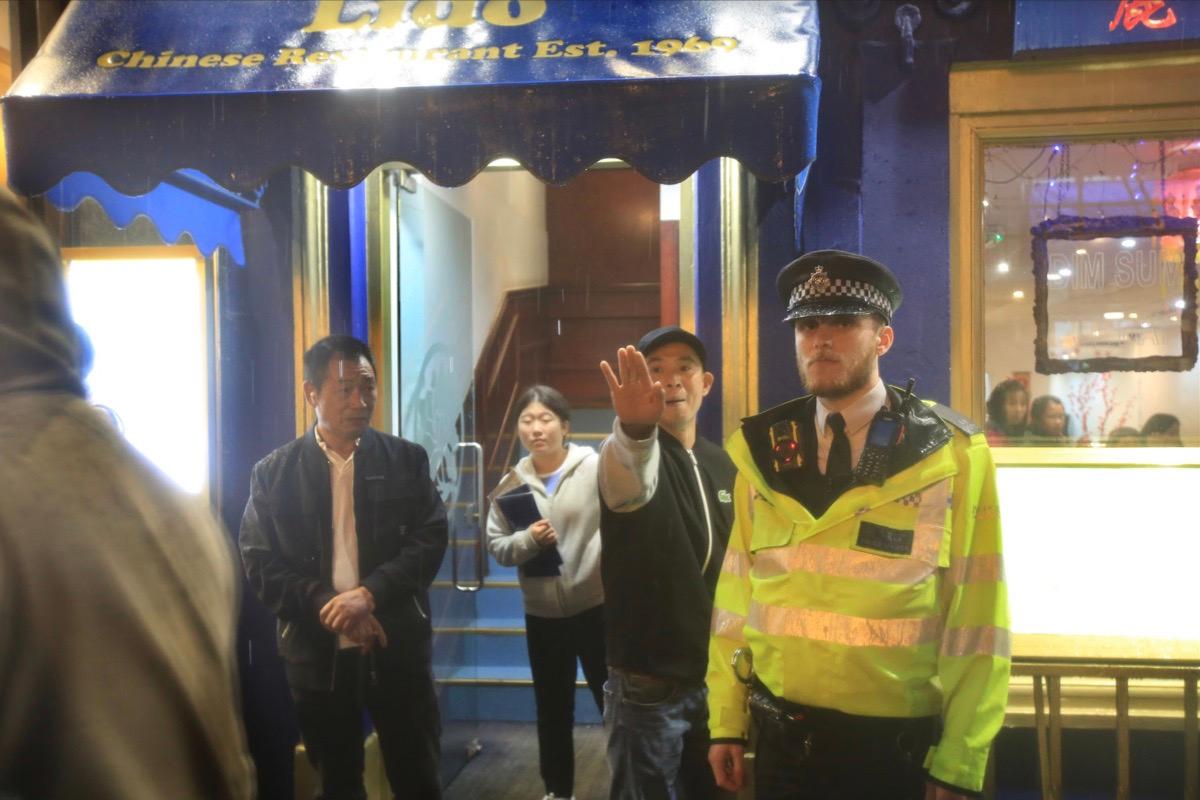 A member of the public comes out from a Chinese restaurant to remonstrate with the protesters as they pass through Chinatown on Oct. 23, 2022, in London, United Kingdom. (Martin Pope/Getty Images)