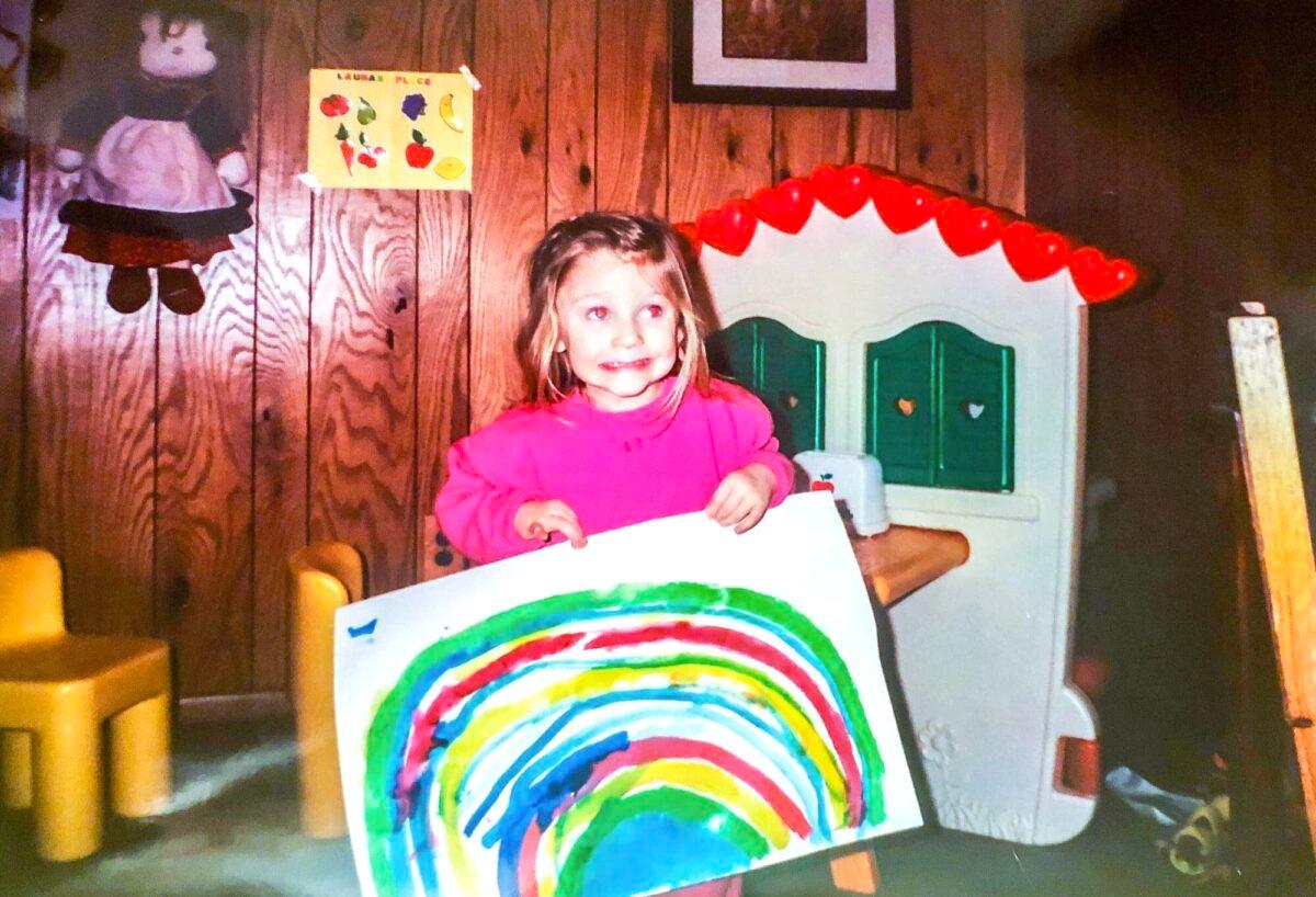 Laura Becker at preschool age displaying one of her early artworks. (Courtesy of Laura Becker)