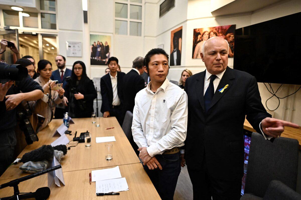 Former Conservative Party leader Sir Iain Duncan Smith (R) speaks with Hong Kong pro-democracy protester Bob Chan (C) at the end of his press conference in London on Oct. 19, 2022. (Ben Stansall/AFP via Getty Images)