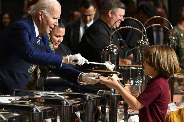 President Joe Biden serves food to military families during a "Friendsgiving" celebration in honor of the upcoming Thanksgiving holiday at the Marine Corps Air Station in Cherry Point, North Carolina, on November 21, 2022. (Jim Watson/Getty Images)