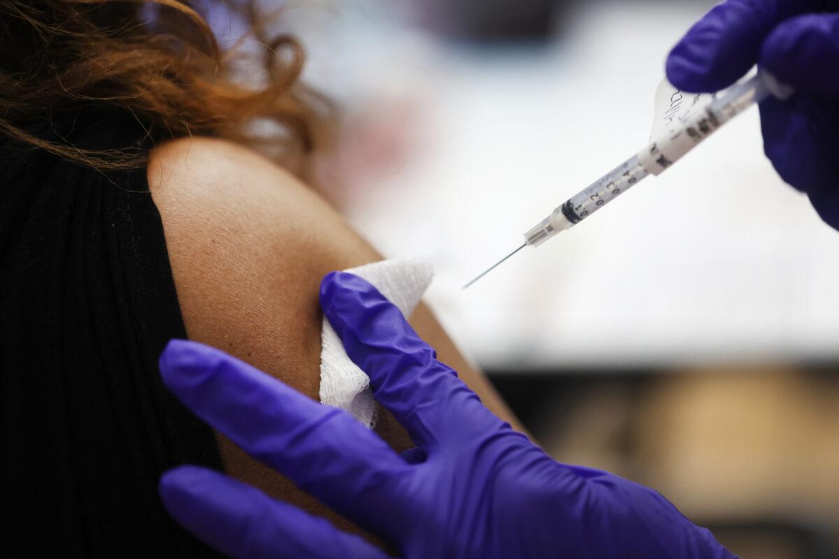 A nurse administers a COVID-19 vaccine booster to a person at a hospital in Hines, Ill., on April 1, 2022. (Scott Olson/Getty Images)