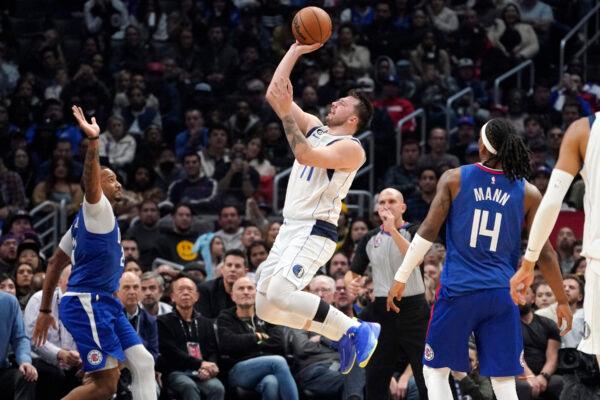Dallas Mavericks guard Luka Doncic, center, shoots as Los Angeles Clippers forward Norman Powell, left, and guard Terance Mann defend during the second half of an NBA basketball game in Los Angeles on Jan. 10, 2023. (Mark J. Terrill/AP Photo)