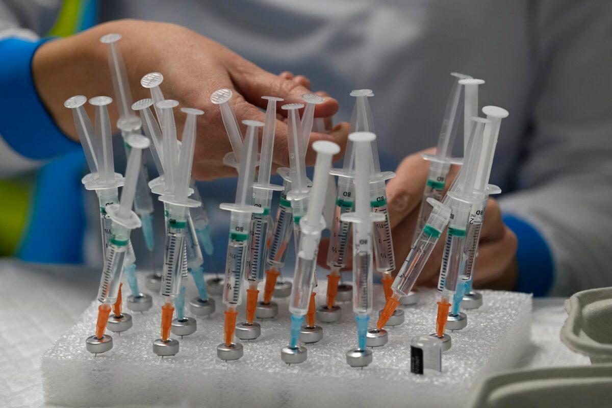 A nurse prepares vaccines in the Wizink Center for COVID-19 vaccinations in Madrid on Dec. 1, 2021. (Paul White/AP Photo)