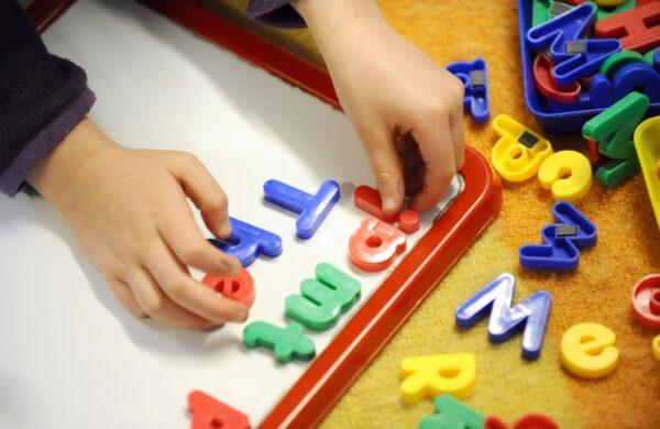 An undated image of a child playing with magnetic letters in a pre-school nursery in the United Kingdom. (PA)