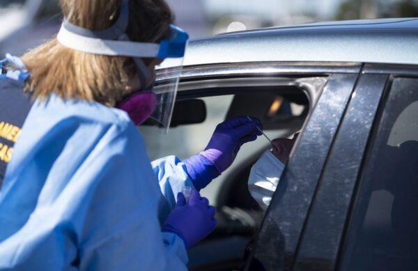 A paramedic administers a nasal swab at a drive-through COVID-19 test site in Ottawa on Sept. 20, 2020. (The Canadian Press/Justin Tang)