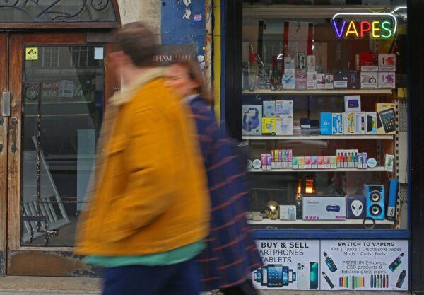 People walk past a newsagent advertising the sale of vape electronic cigarettes in Streatham Hill, in south London, on April 1, 2023. (Susannah Ireland/AFP via Getty Images)