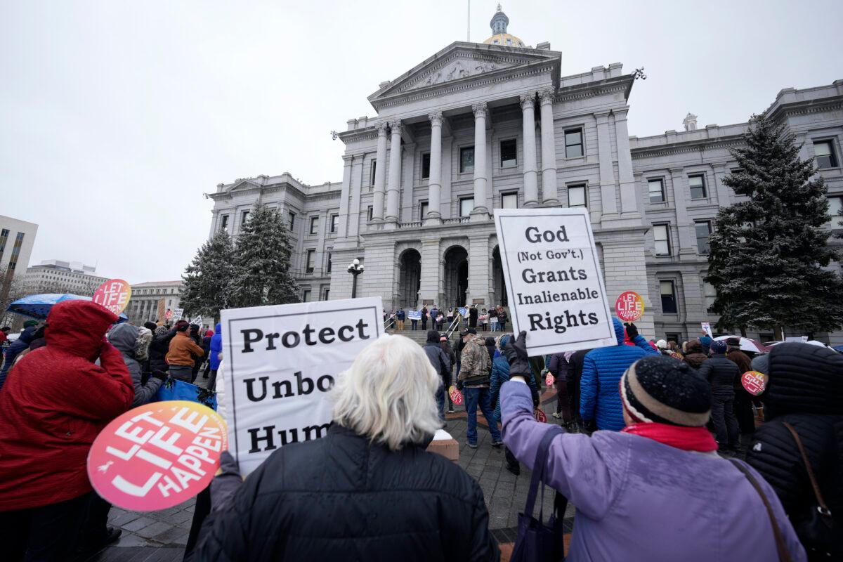 Attendees wave placards during a rally on the first anniversary of the passage of Colorado's abortion law, the Reproductive Health Equity Act, outside the state Capitol in Denver on April 4, 2023. (David Zalubowski/AP Photo)