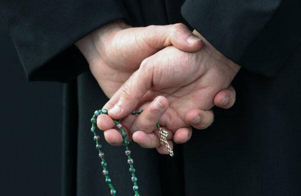 Un hombre sostiene un rosario afuera de una iglesia católica de EE. UU. (Rob Carr/Getty Images)