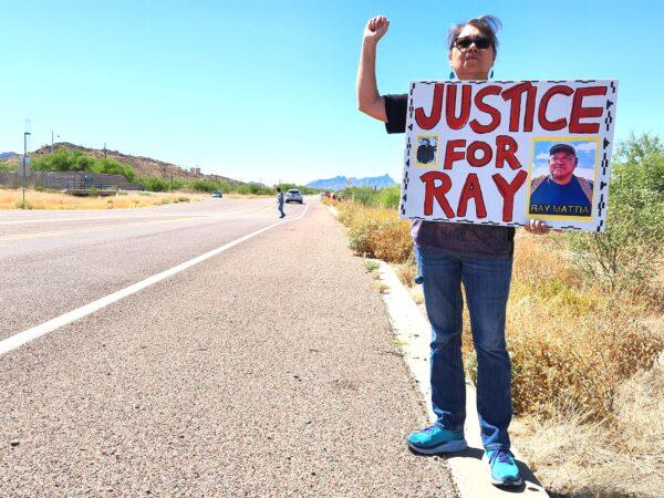Raymond Mattia's first cousin, Tina, raises a fist during a protest outside the Ajo Border Patrol Station in Why, Ariz., on May 27, 2023. (Allan Stein/The Epoch Times)