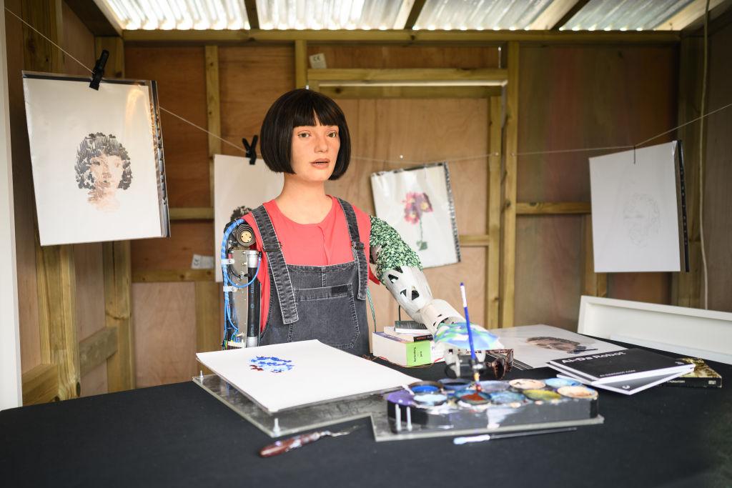 Ai-DA, the world's first robot artist, paints portraits of the headline acts in the Ai-DA Robot Booth in the Shangri La Field, during day two of Glastonbury Festival at Worthy Farm, Pilton in Glastonbury, England, on June 23, 2022. (Leon Neal/Getty Images)