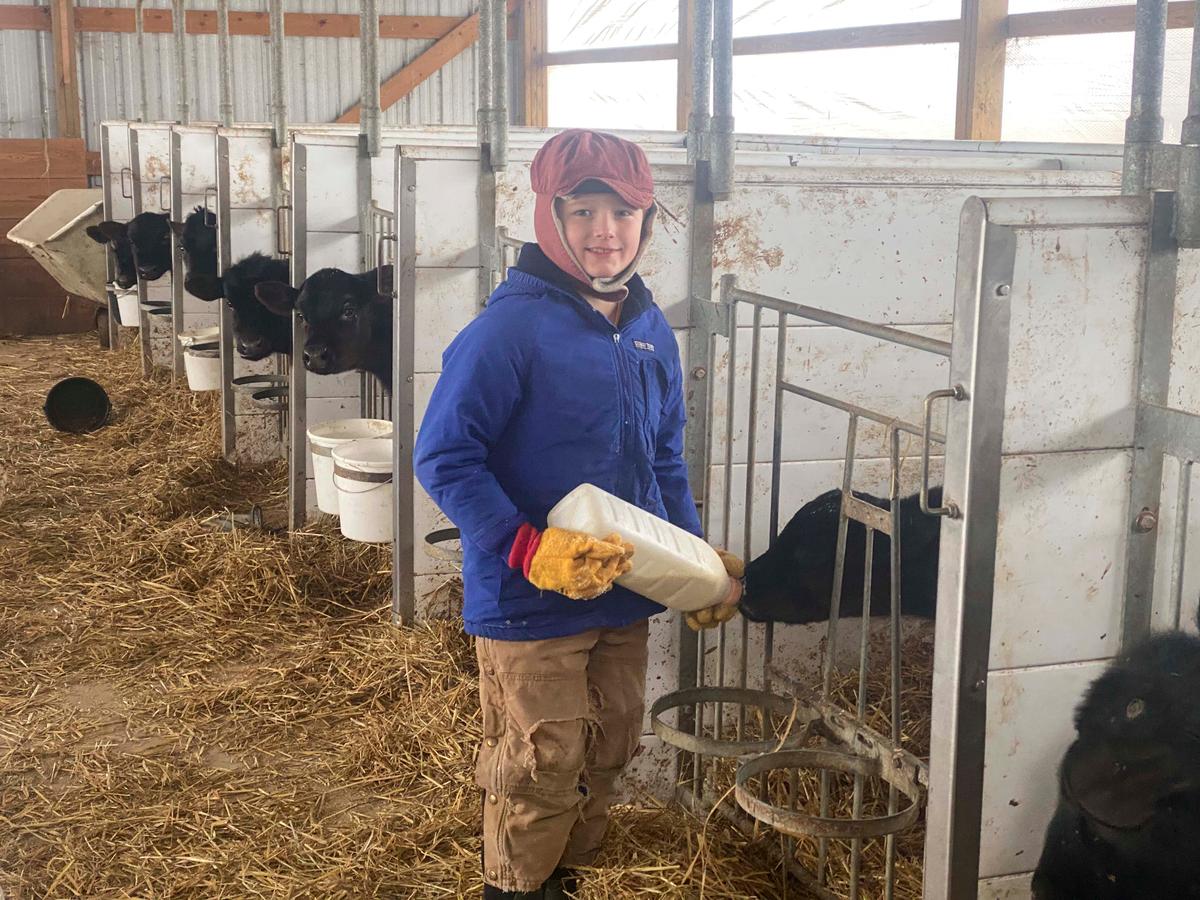 Helping his mom feed the calves in the winter. (Courtesy of Jill Bergner)