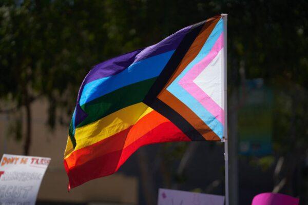 A Progress Pride flag is held above the crowd of LGBT activists during a rally in West Hollywood, Calif., on April 9, 2023. (Allison Dinner/AFP via Getty Images)
