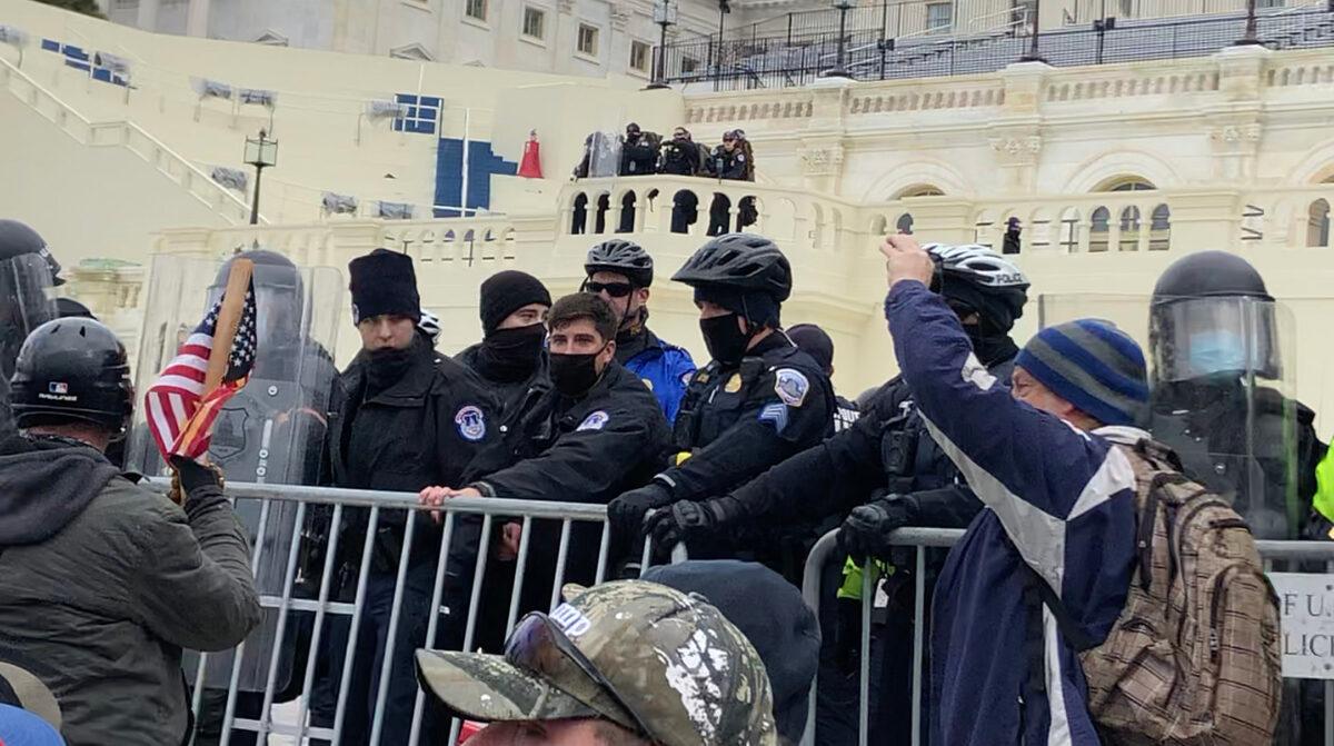 U.S. Capitol Police officers attempt to maintain the barrier on the west front of the Capitol on Jan. 6, 2021. (Steve Baker/Special to The Epoch Times)
