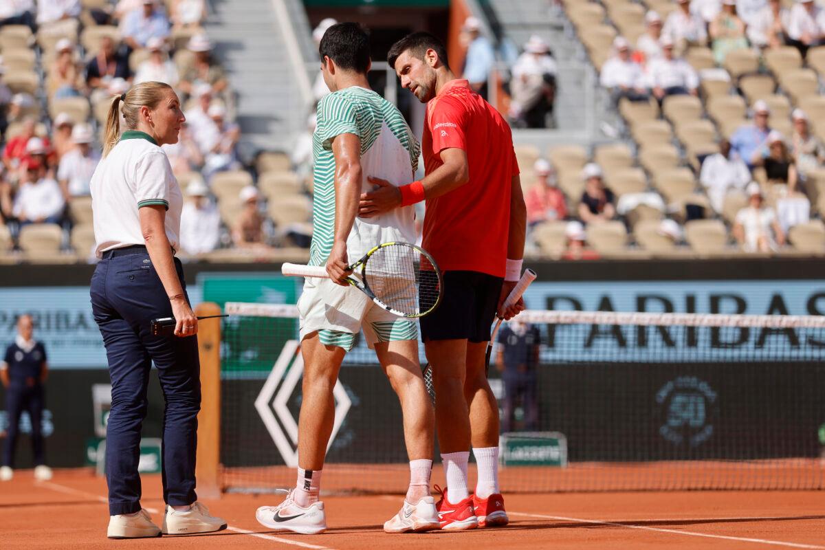 Carlos Alcaraz (C) walks with the help of Novak Djokovic (R) as he is injured during their semifinal match of the French Open tennis tournament at the Roland Garros stadium in Paris on June 9, 2023. (Jean-Francios Badias/AP Photo)