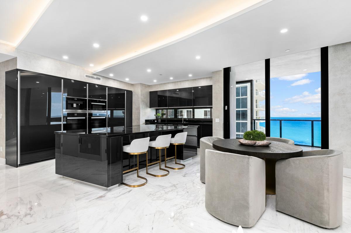 The well-equipped kitchen with a breakfast bar is conveniently just a few steps away from the dining room and the adjacent terrace with a private pool. (Courtesy of The Carroll Group)