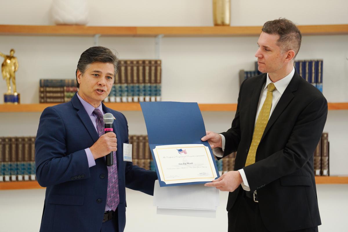 Joseph Paone (L), a representative from Rep. Patrick Ryan’s (D-N.Y.) office, presents the congressman's certificate of appreciation to Nick Janicki, director of media relations of Gan Jing World, at the company's opening ceremony of its first headquarters building, dubbed "MT0" or "Middletown Zero," in Middletown, N.Y., on June 22, 2023. (Samira Bouaou/The Epoch Times)