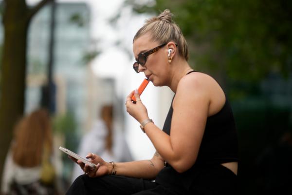 A woman smokes a vaping device in Manchester, England, on May 30, 2023. (Christopher Furlong/Getty Images)