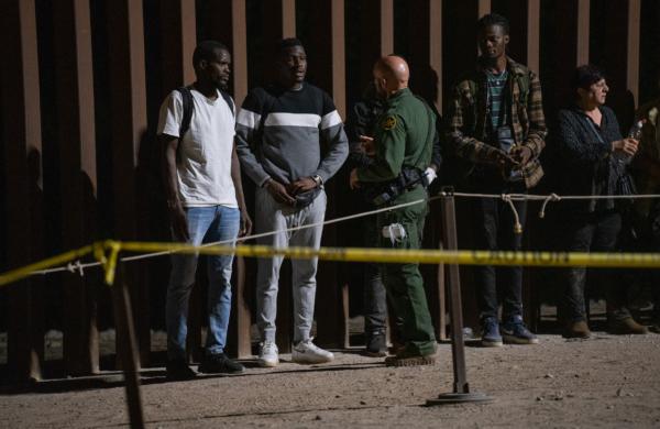 Men from Ghana talk with a U.S. Border Patrol agent in Yuma, Ariz., on May 18, 2023. (John Fredricks/The Epoch times)