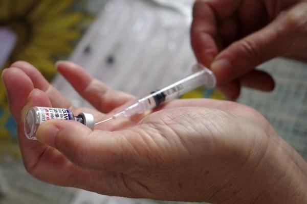 A health care worker prepares a Pfizer COVID-19 vaccine, in a file photograph. (Bay Ismoyo/AFP via Getty Images)