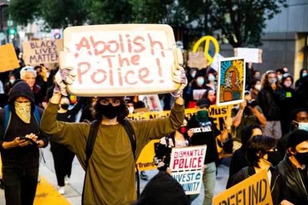 Protesters hold signs in support of defunding the police in Oakland, Calif., on July 25, 2020. (Natasha Moustache/Getty Images)